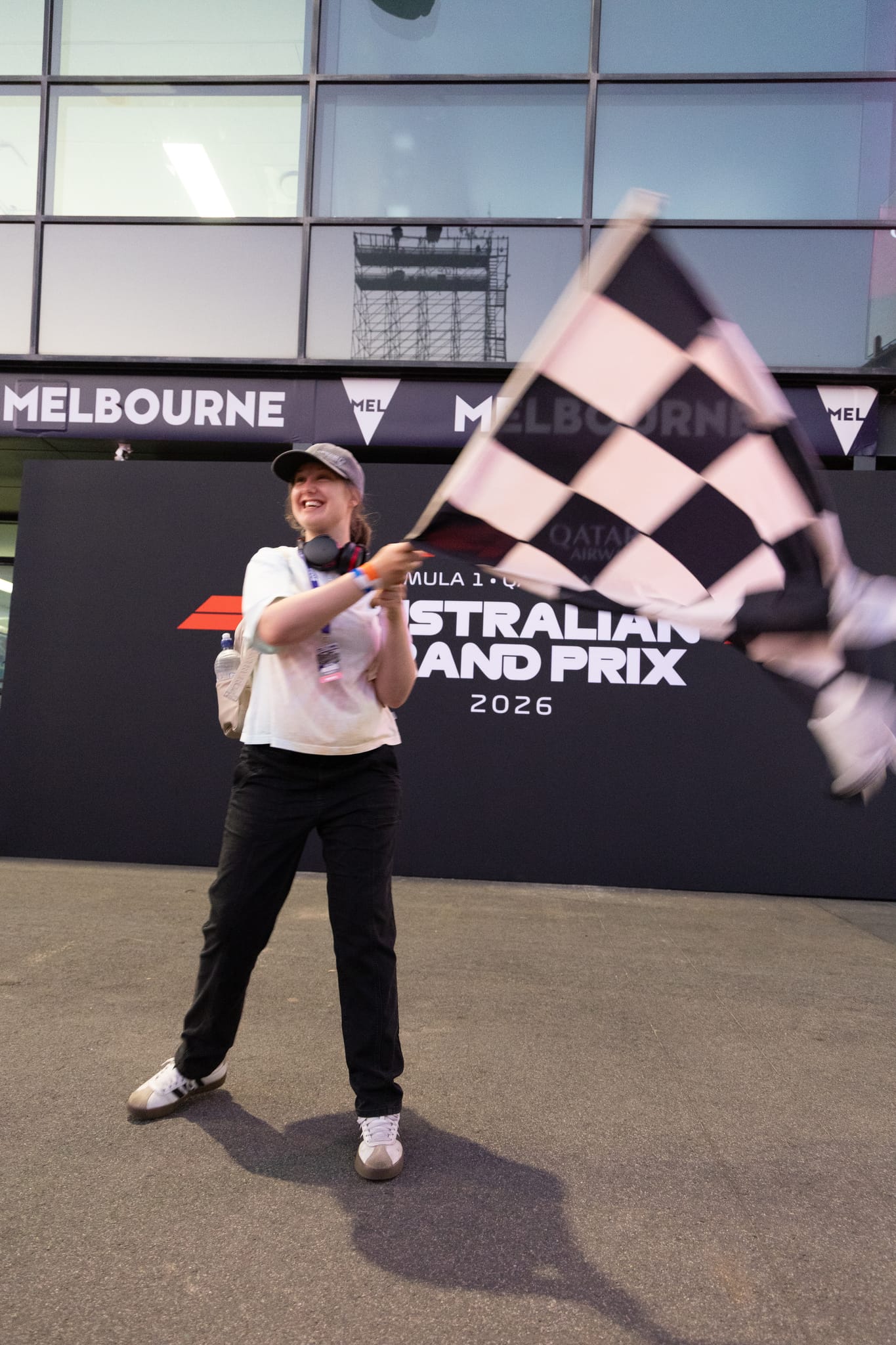 A What Ability volunteer waving the chequered flag at the Australian Grand Prix
